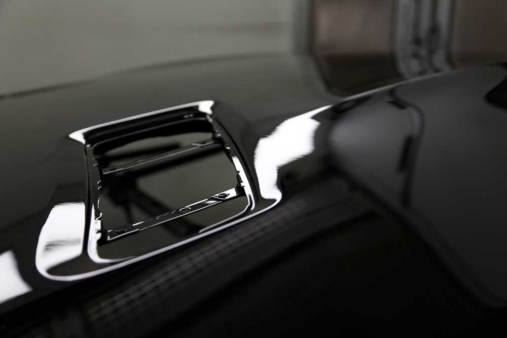 Hagelschadenbeseitigung-Nahaufnahme eines reparierten Hagelschadens eines schwarzen Autos