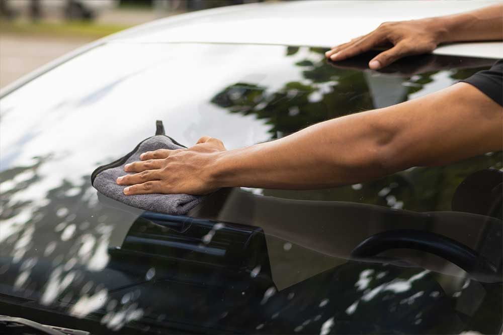 Austausch Windschutzscheibe-Nahaufnahme einer Windschutzschiebe, die von einem Mitarbeiter gereinigt wird